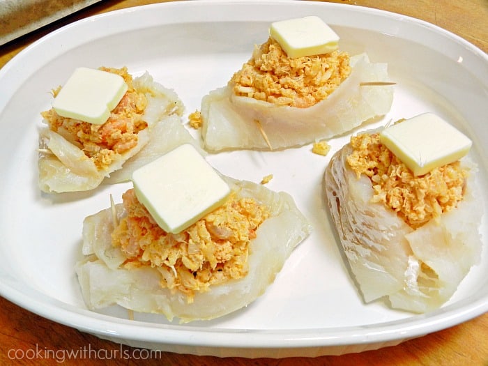Shrimp and Crab Stuffed Cod topped with butter in a white baking dish 