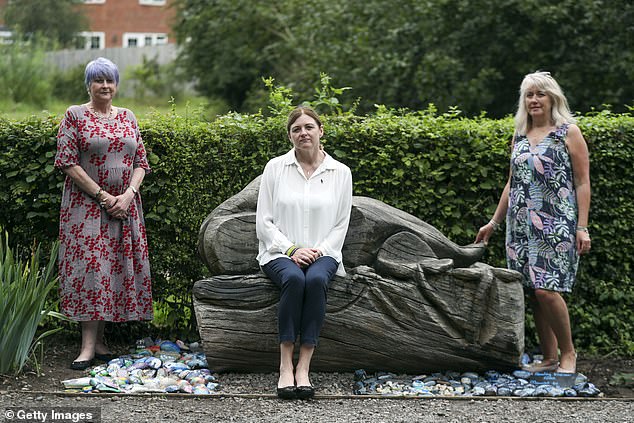Deborah Adlam (centre) alongside Debor Baldree (left) and Wendy Harriss who co-run Reading Kindness Rocks, next to a memorial for the police officer on the first anniversary of his death