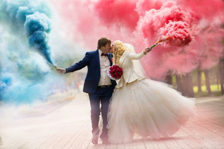Жених и невеста с шашками цветного дыма