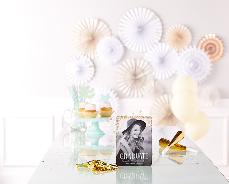 graduation announcement displayed on grad party table with cupcakes